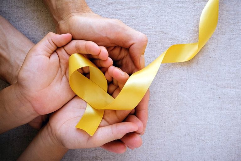 adult and child hands holding yellow gold ribbon, Sarcoma Awaren